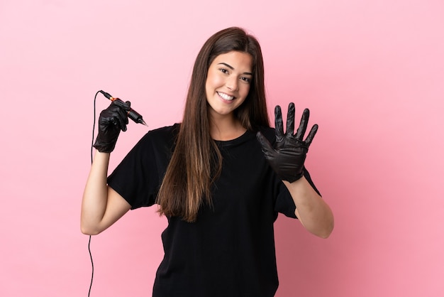 Mulher do tatuador isolada em um fundo rosa contando cinco com os dedos