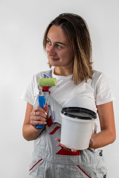 Mulher do trabalhador da construção civil com sorriso bonito com ferramentas no fundo branco