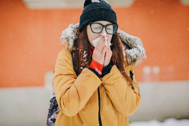 Foto mulher doente assoar o nariz no tecido ao ar livre