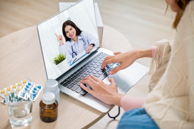 Mulher doente chamada de vídeo on-line com laptop consulta com médico com pílulas de entrega pacote em casa mulher doente coberta cobertor pesquisando informações médicas on-line Medicina e saúde