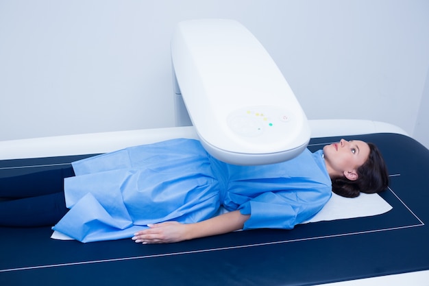 Mulher doente deitada em uma máquina de raios-x