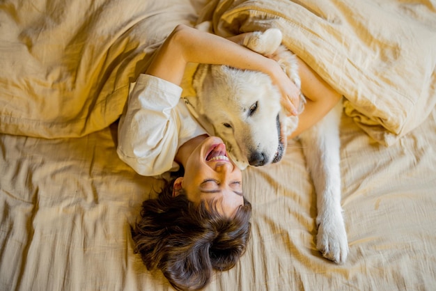 Mulher dorme com seu cachorro fofo na cama