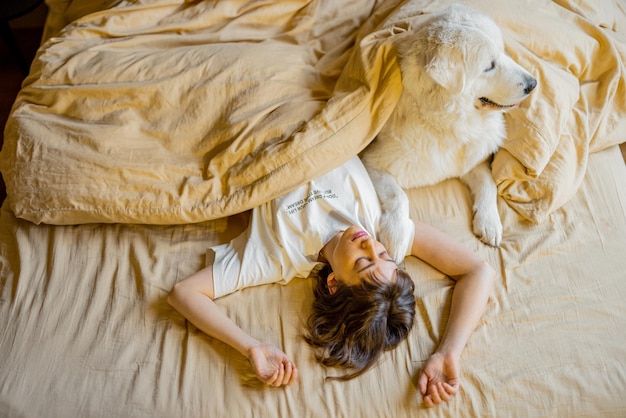 Mulher dorme com seu cachorro fofo na cama