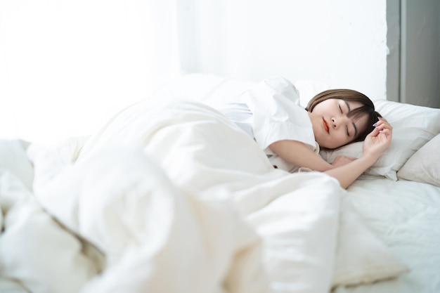 Mulher dormindo em uma cama em um quarto iluminado