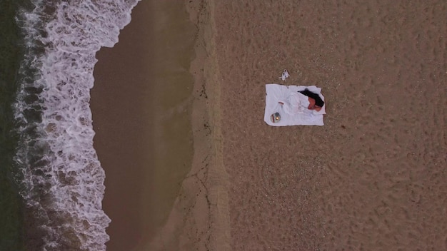 Mulher dormindo na praia na cama ao pôr do sol