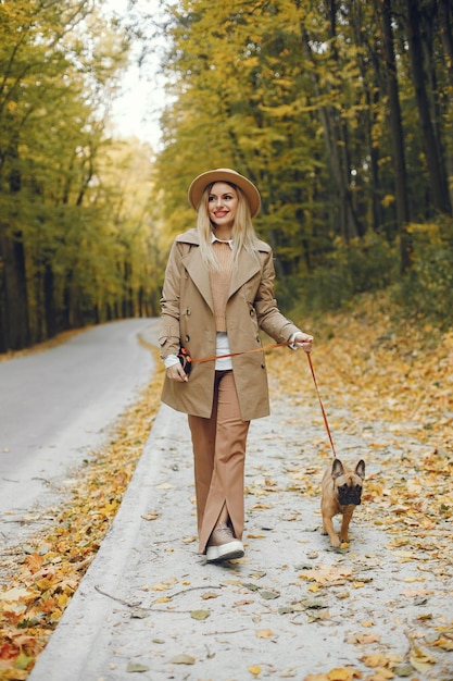 Mulher e cachorro brincam e se divertem no parque de outono