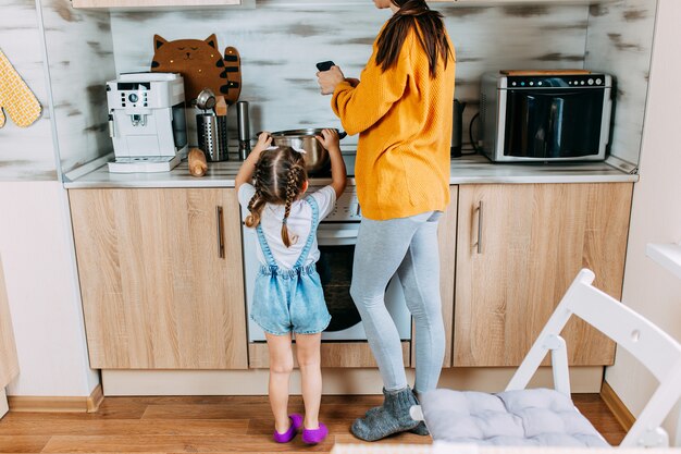 Mulher e filha estão cozinhando juntos