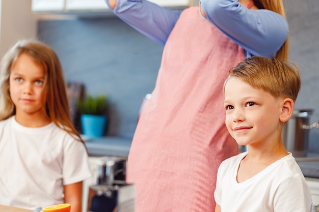 Mulher e filhos cozinhando na cozinha