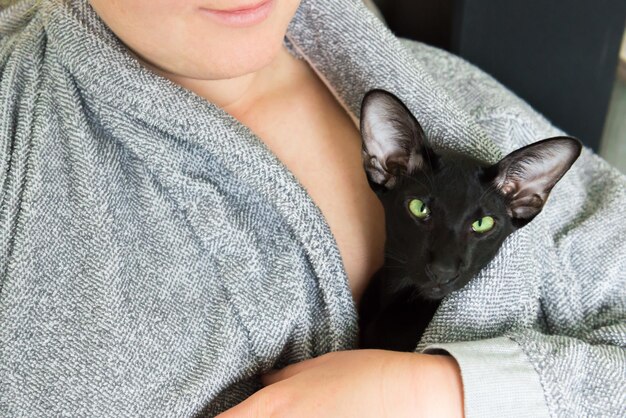 Mulher e gato oriental preto