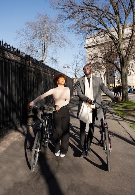 Foto mulher e homem andando com bicicletas na cidade na frança