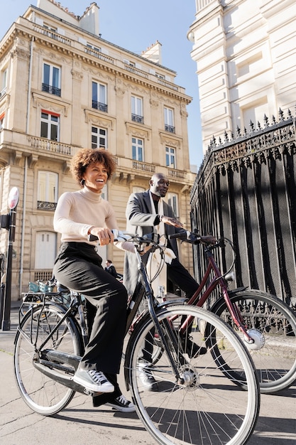 Mulher e homem andando de bicicleta na cidade na frança