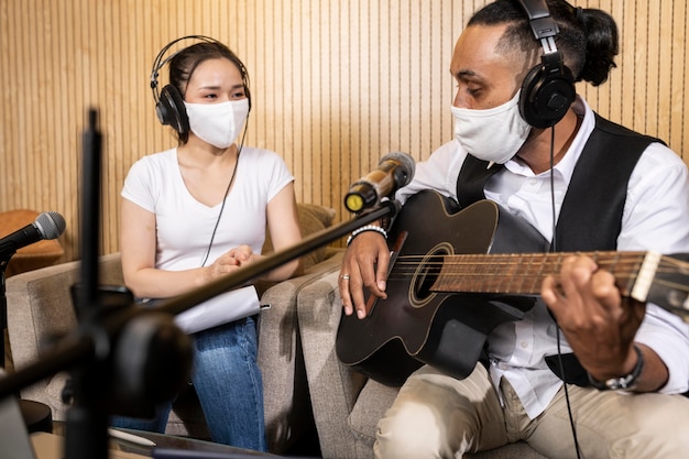 Foto mulher e homem com máscara facial ao vivo no rádio