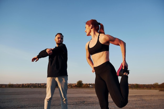 Foto mulher e homem têm dia de fitness na estrada à noite juntos