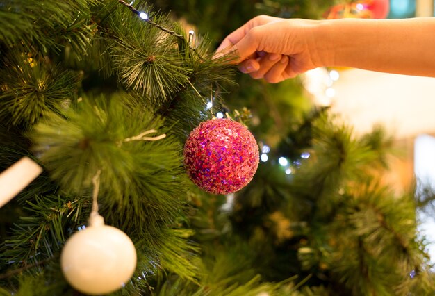 Mulher, é, mão, decorando, um, árvore natal, com, bola