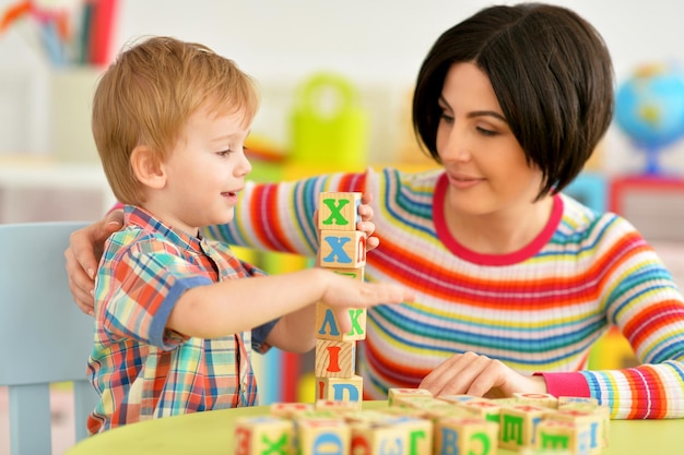 Mulher e menino brincando com cubos