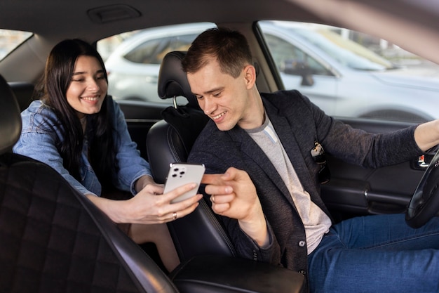 Foto mulher e motorista olhando para um telefone plano médio