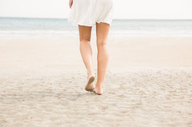 Mulher elegante caminhando na areia