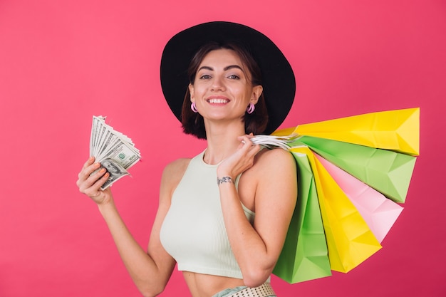 Mulher elegante com chapéu na parede rosa vermelha