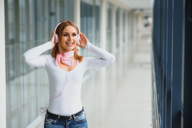 Mulher elegante com fones de ouvido no aeroporto