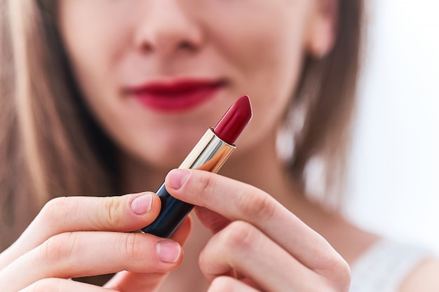 Mulher elegante com lábios vermelhos e clássico batom vermelho brilhante.