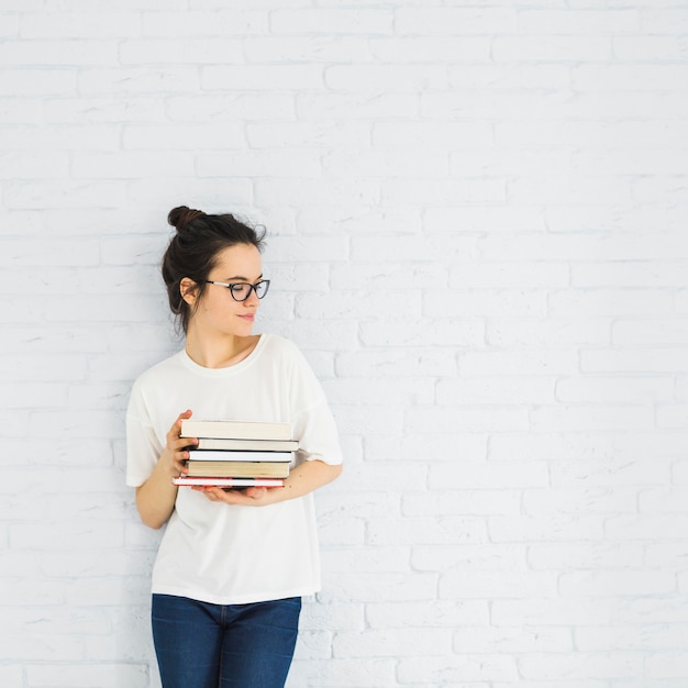 Mulher elegante com pilha de livros