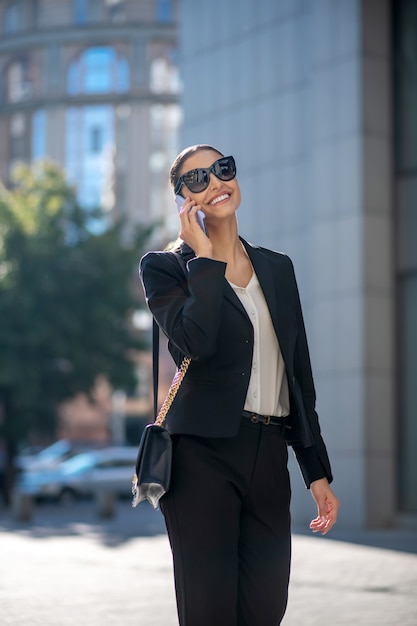 Mulher elegante de cabelos escuros falando ao telefone