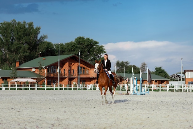 Mulher elegante de cavaleiro montando seu cavalo lá fora