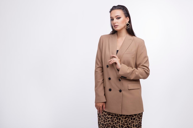 mulher elegante de terno marrom e bege, jaqueta, saia de leopardo em fundo branco