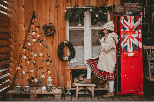 Mulher elegante decorada terraço de férias de ano novo estilo moderno eco rústico mínimo Bandeira britânica Estilo escandinavo feito à mão no Natal. Idéias de decoração de interiores janela de madeira barata, material natural