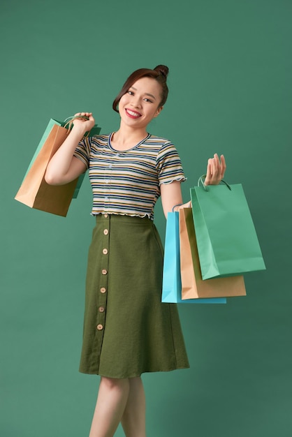 Mulher elegante e atraente viciada em compras andando segurando sacolas de compras