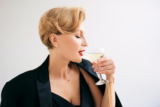 mulher elegante elegante madura de smoking com copo de vinho espumante. Festa, celebração, anti idade