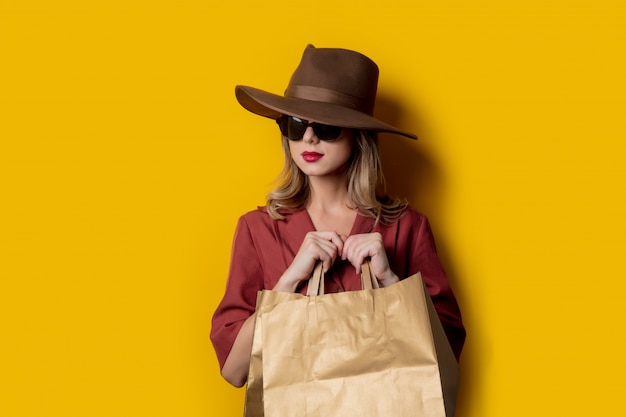 Mulher elegante em óculos de sol e com sacolas de compras