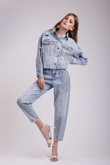 Mulher elegante em uma linda jaqueta jeans jeans grande com calças de strass no fundo branco