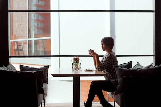 Mulher elegante no café no sofá