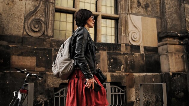 Mulher elegante passeia por ruas turísticas históricas em Dresden com mochila