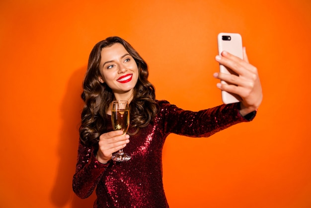 Mulher elegante posando contra a parede laranja