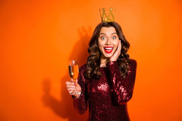 Mulher elegante posando contra a parede laranja