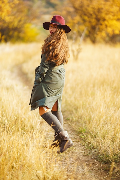 Mulher elegante vestindo um casaco no parque de outono