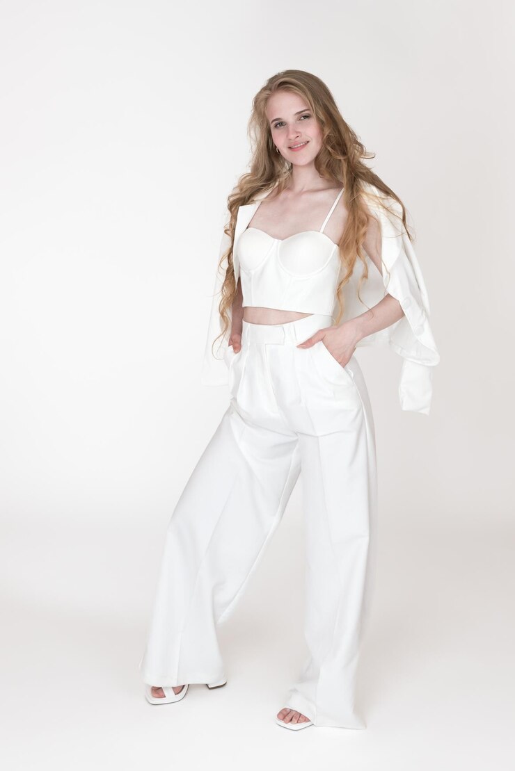 Mulher elegantemente vestida com uma jaqueta de terno branco esculpindo calças superiores de espartilho e slingbacks
