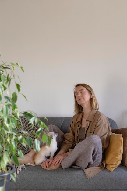 Mulher em casa descansando e ouvindo meditação no sofá