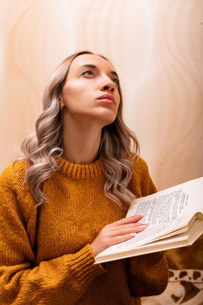 Foto mulher em casa no sofá lendo um livro escritório em casa aprendizagem a distância