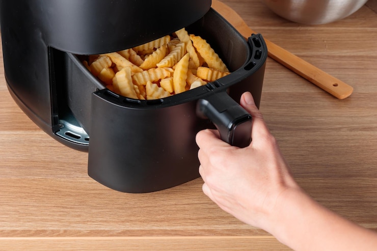 Mulher em casa usando aparelho de cozinha de moda máquina de fritura de ar cozinha batata frita pequena mesa forno de convecção frita rápida frita óleo livre maneira mais saudável de cozinhar comida frita