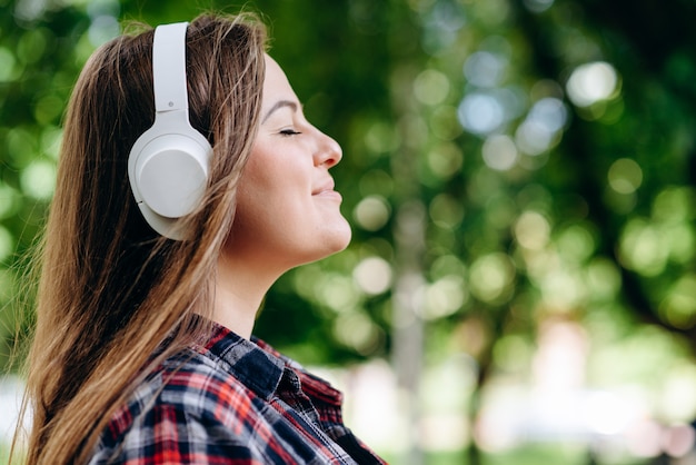 mulher em fones de ouvido na natureza,