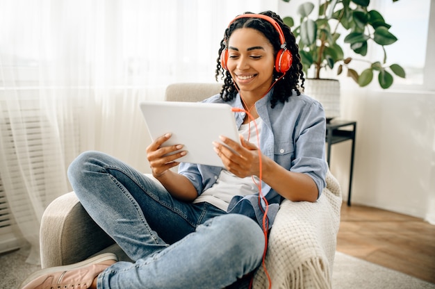 Foto mulher em fones de ouvido, ouvindo música do tablet pc.