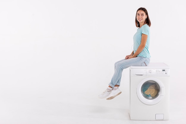 Mulher em foto posando na máquina de lavar