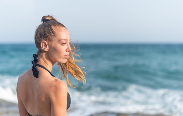 Mulher em frente ao mar de biquíni