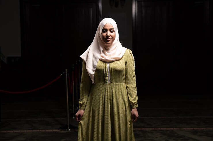 Foto mulher em hijab sentada na mesquita e rezando