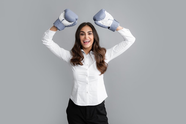 Mulher em luvas de boxe Retrato de negócios criativos de uma mulher em um terno de escritório com luvas de boxe Fundo cinza