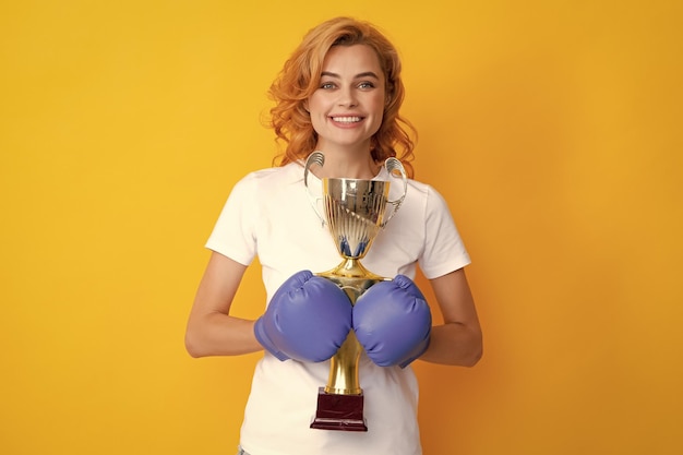 Mulher em luvas de boxe segura o troféu da taça vencedora campeã Conceito de mulher de poder de sucesso vencedor
