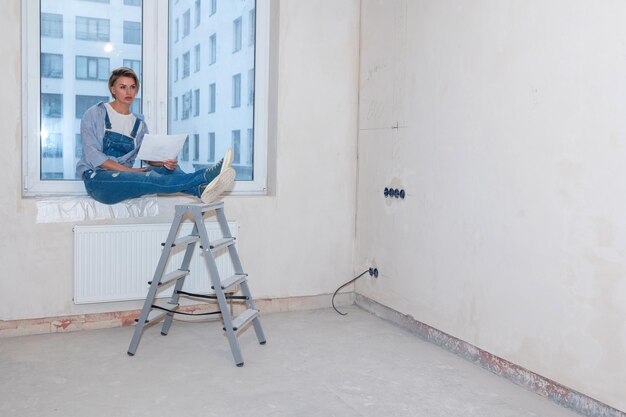 Mulher em novo apartamento com sonhos de uma nova vida Renovação em novo apartamento Trabalho de reparação em casa